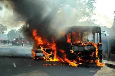 6 Ocak 2015 'te BNP liderliğindeki 20 partili ittifakın yürüttüğü ülke çapındaki abluka programının ilk gününde, muhalefet göstericileri tarafından ateşe verilen araçlar.