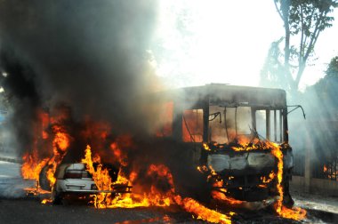 6 Ocak 2015 'te BNP liderliğindeki 20 partili ittifakın yürüttüğü ülke çapındaki abluka programının ilk gününde, muhalefet göstericileri tarafından ateşe verilen araçlar.