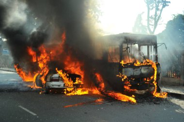 6 Ocak 2015 'te BNP liderliğindeki 20 partili ittifakın yürüttüğü ülke çapındaki abluka programının ilk gününde, muhalefet göstericileri tarafından ateşe verilen araçlar.