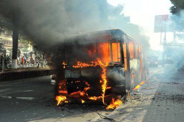 6 Ocak 2015 'te BNP liderliğindeki 20 partili ittifakın yürüttüğü ülke çapındaki abluka programının ilk gününde, muhalefet göstericileri tarafından ateşe verilen araçlar.
