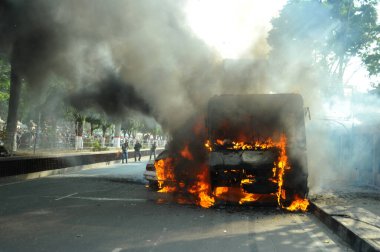6 Ocak 2015 'te BNP liderliğindeki 20 partili ittifakın yürüttüğü ülke çapındaki abluka programının ilk gününde, muhalefet göstericileri tarafından ateşe verilen araçlar.