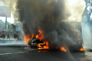 6 Ocak 2015 'te BNP liderliğindeki 20 partili ittifakın yürüttüğü ülke çapındaki abluka programının ilk gününde, muhalefet göstericileri tarafından ateşe verilen araçlar.