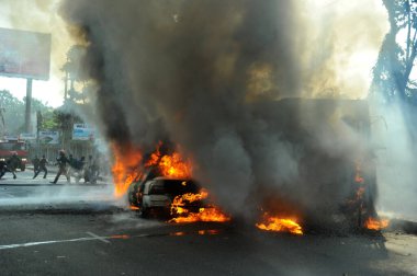 6 Ocak 2015 'te BNP liderliğindeki 20 partili ittifakın yürüttüğü ülke çapındaki abluka programının ilk gününde, muhalefet göstericileri tarafından ateşe verilen araçlar.