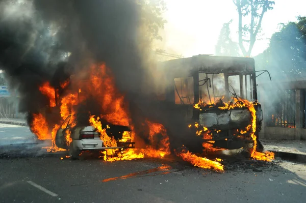 6 Ocak 2015 'te BNP liderliğindeki 20 partili ittifakın yürüttüğü ülke çapındaki abluka programının ilk gününde, muhalefet göstericileri tarafından ateşe verilen araçlar.
