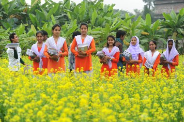 Bangladeş Köyü öğrencisi 1 Ocak 2015 'te Dhaka, Bangladeş' in Manikganj İlçesi 'nde ders kitaplarıyla toplanma alanında okula gidiyor.