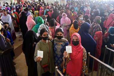 Kadınlar, Bangladeş 'in Dhaka kentindeki Kamalapur Tren İstasyonu' nda bayram öncesi bilet almak için kuyruğa giren insanlar olarak 23 Nisan 2022 'de Bangladeş Demiryolları, Kurban Bayramı öncesinde ön bilet satmaya başlarken tren biletlerini gösteriyorlar.. 