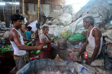 Laborers sort through polyethylene terephthalate (PET) bottles in a recycling factory in Dhaka, Bangladesh, on July 27, 2022. Recycling plastic bottles has become a growing business over the last couple of years as well as helping to protect the envi