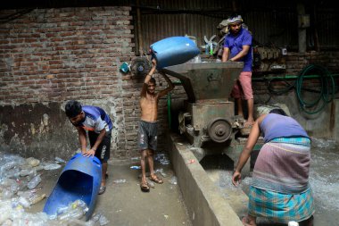 İşçiler 27 Temmuz 2022 'de Dhaka, Bangladeş' teki bir geri dönüşüm fabrikasında plastik şişe kullandılar. Plastik şişelerin geri dönüşümü son birkaç yıl içinde büyüyen bir iş haline geldi ve çevrenin korunmasına yardımcı oldu. B 'ye göre...