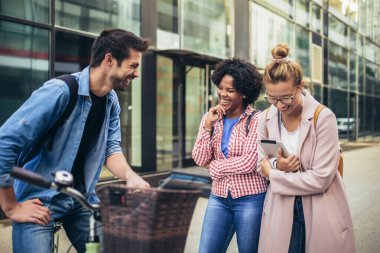 Üniversite öğrencileri kampüste açık havada okuyor.