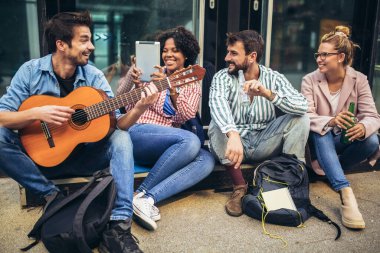 Bir grup genç şehirde takılıyor. Oturuyorlar, şarkı söylüyorlar ve gitar çalıyorlar..