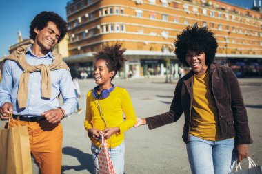 Mutlu genç melez çift kızlarıyla alışverişte vakit geçiriyor..