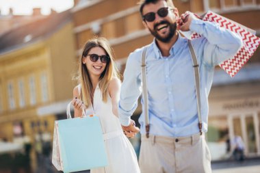 Bir çift turist şehir caddesinde yürüyor, alışveriş yapıyor, eğleniyorlar.