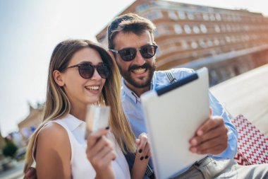 Çevrimiçi alışveriş için dijital tablet kullanan genç çift.