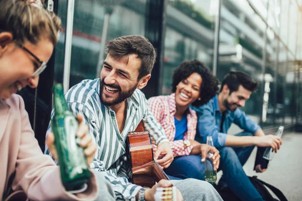 Ομάδα Νεαρών Φίλων Συχνάζουν Στην Πόλη Κάθονται Τραγουδούν Και Παίζουν — Φωτογραφία Αρχείου