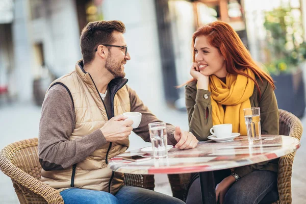 魅力的な若いカップルで愛のカフェテーブルに座って屋外で コーヒーを飲む — ストック写真
