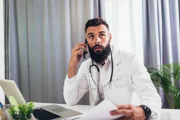 Mužský Lékař Analyzující Výsledky Lékařského Odpočinku Při Komunikaci Pacientem Telefonu — Stock fotografie