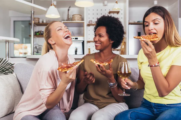 Evdeki kanepede şarap ve pizzayla mutlu genç bayan arkadaşlar.. 