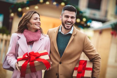 Genç romantik çift, Noel 'den önce hediye kutusuyla dışarıda eğleniyor..