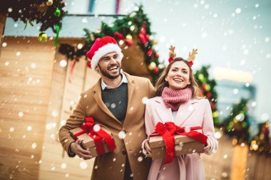 Genç romantik çift, Noel 'den önce hediye kutusuyla dışarıda eğleniyor..