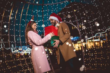 Genç romantik çift, Noel 'den önce hediye kutusuyla dışarıda eğleniyor..