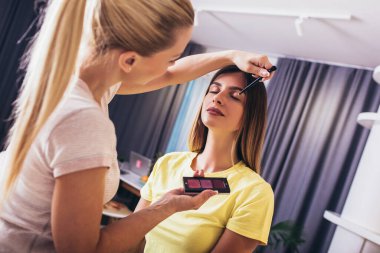 Makyaj sanatçısı bayan arkadaşı üzerinde çalışıyor..