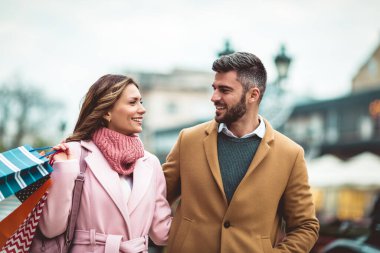 Alışveriş torbalarıyla mutlu bir çiftin portresi..