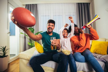 Evde televizyon izlerken aile Amerikan futbolu maçı