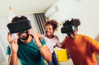 Aile video oyunu VR gözlükleriyle oynuyor.