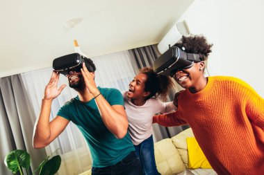 Aile video oyunu VR gözlükleriyle oynuyor.