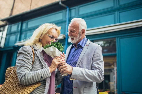 Romântico Homem Sênior Dando Flores Sua Esposa — Fotografia de Stock