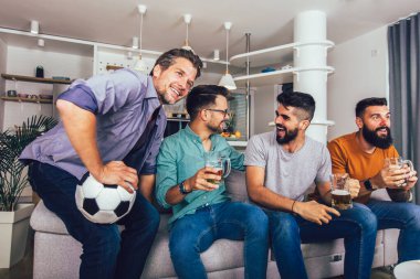 Çok heyecanlı arkadaşlar evde, içeride futbol maçı izleyerek eğleniyorlar. Arkadaşlık, eğlence, spor, dinlenme, ev partisi konsepti