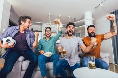 Çok heyecanlı arkadaşlar evde, içeride futbol maçı izleyerek eğleniyorlar. Arkadaşlık, eğlence, spor, dinlenme, ev partisi konsepti
