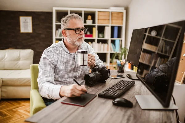 Evindeki ofisinde çalışırken sakallı bir fotoğrafçı..