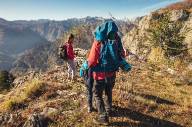 Babası ve iki çocuğu dağda yürüyüş yapıyor.