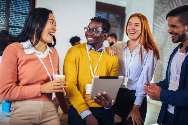 Ofiste dikilirken dijital tablet kullanan mutlu iş arkadaşları