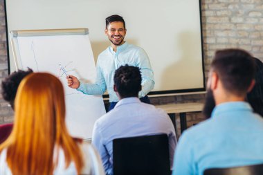Seminerde konuşmacı, başarı anahtarı için iş toplantısı için birçok seyirciyle konuşuyor.