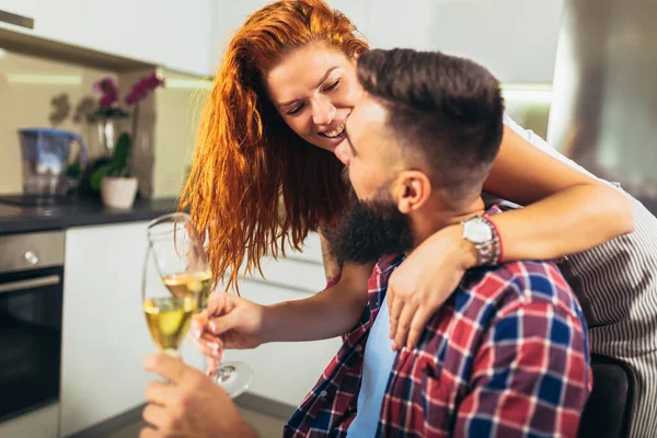 若いですカップルで愛飲むワインで家のキッチン — ストック写真