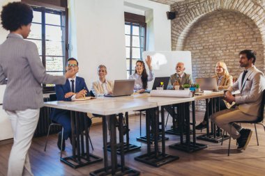 İşletme atölyesi sözcüsü ofisteki meslektaşlarına pozitif iş büyümesi hakkında bir sunum yapıyor..