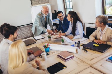 İşletme atölyesi sözcüsü ofisteki meslektaşlarına pozitif iş büyümesi hakkında bir sunum yapıyor..
