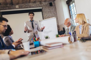 İşletme atölyesi sözcüsü ofisteki meslektaşlarına pozitif iş büyümesi hakkında bir sunum yapıyor..