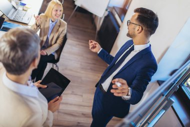 İşletme ekibi ofisteki beyaz tahtayla ilgili yeni fikirler üzerinde çalışıyor.