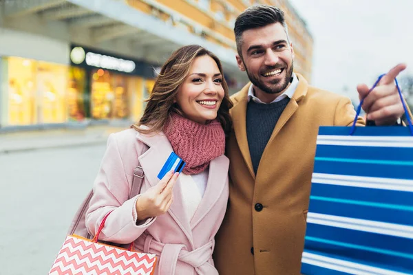 クレジットカードを持って買い物をした後の若い幸せなカップル — ストック写真