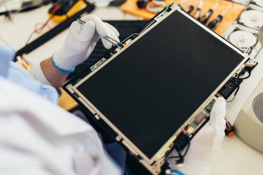 Mühendis bozuk bilgisayar ekipmanlarını tamir ediyor. Elektronik tamir atölyesi, teknoloji geliştirme konsepti