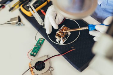 Mühendis bozuk bilgisayar ekipmanlarını tamir ediyor. Elektronik tamir atölyesi, teknoloji geliştirme konsepti