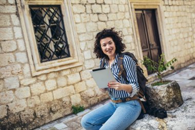 Tatil gezisinde tablet kullanan gezgin kadın..