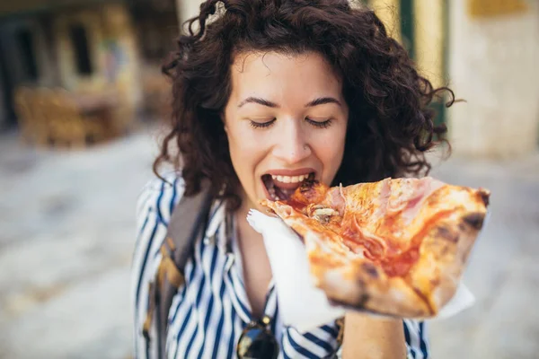 美丽的年轻女性游客在户外吃一片披萨 — 图库照片