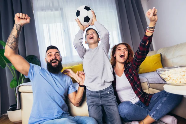 家庭でテレビでサッカーの試合を見ているファンの家族 — ストック写真
