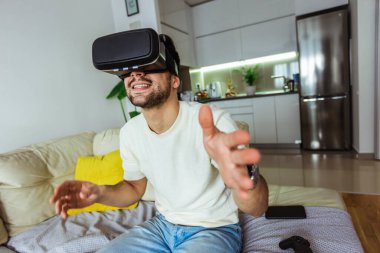 Oturma odasında sanal gerçeklik gözlüğü takan bir adam..