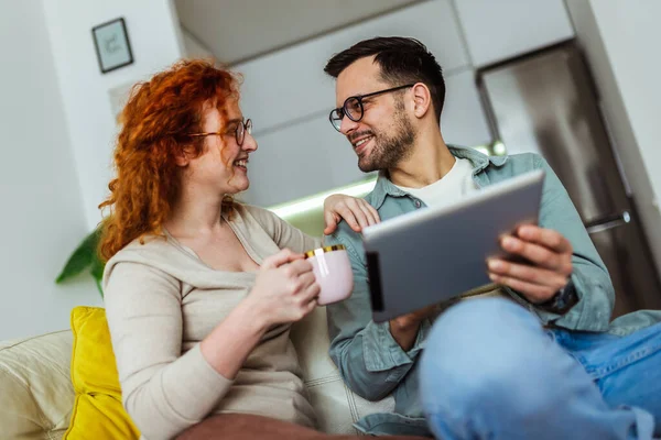 Pareja Joven Viendo Contenido Multimedia Línea Una Tableta Sentada Sofá —  Fotos de Stock