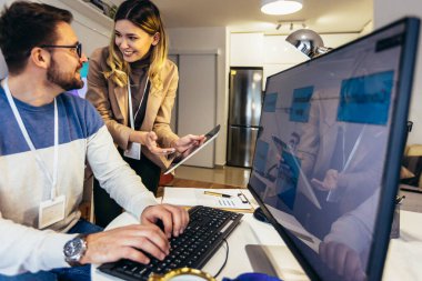 Evde bilgisayar başında çalışan genç bir çift..